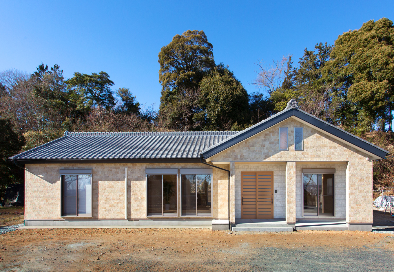 瀧口建設｜玄関を中心からずらし家相に配慮。南側を減築し、夫婦二人にジャストサイズに仕上げた。南壁面は防火サイディングを採用。玄関上部の飾り窓には照明も灯る
