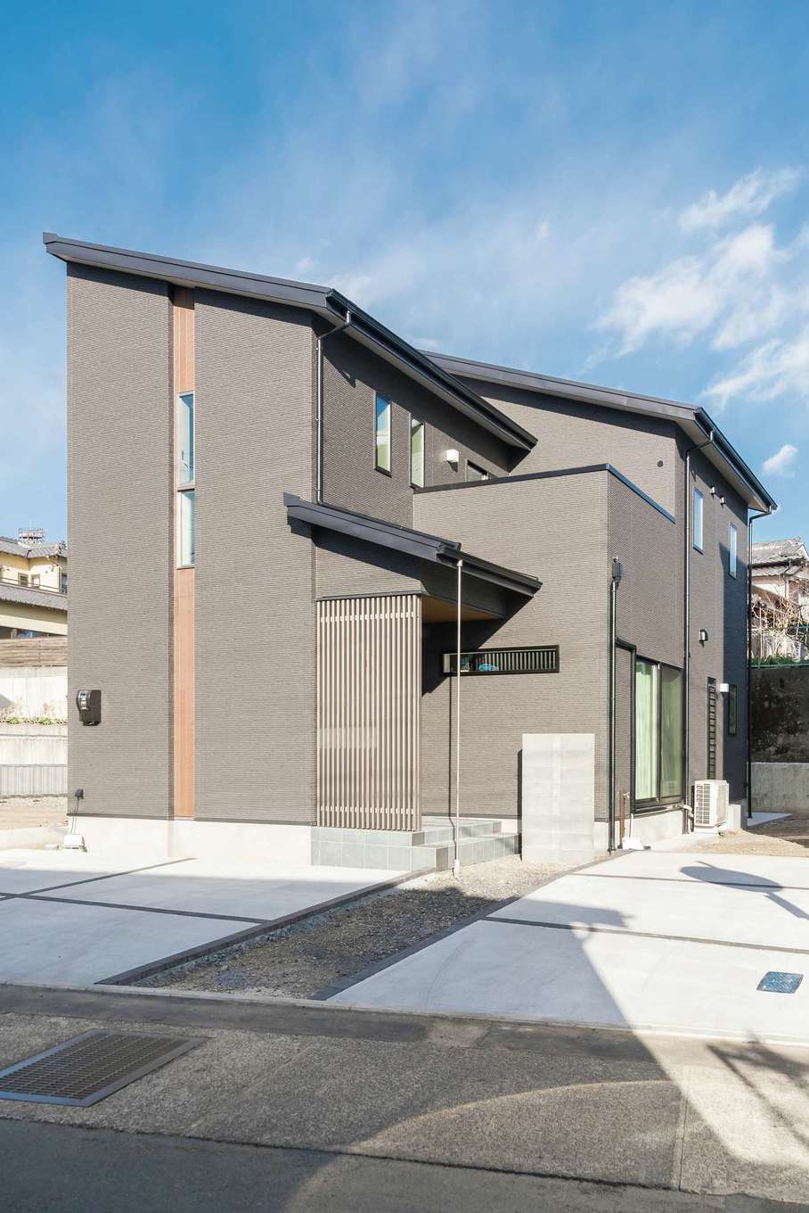 三和建設【子育て、収納力、間取り】勾配天井が印象的な外観。玄関ポーチのコートラインが、通りから玄関への直接の視線を遮ってくれる