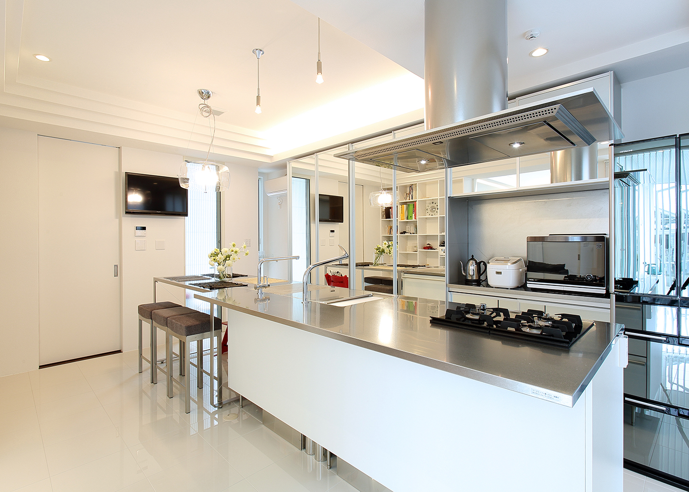 丸昇彦坂建設【デザイン住宅、間取り、ガレージ】メタリックなデザインが目を引くオーダーメイドのキッチン。雰囲気に合わせて周りの家具も揃えることでユニティーな仕上がりに