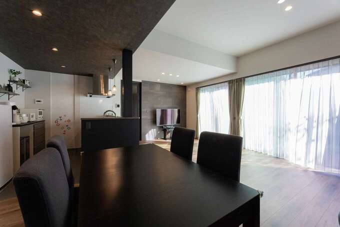 濃いグレーの下がり天井でメリハリを付けた、カフェのようなダイニングスペース