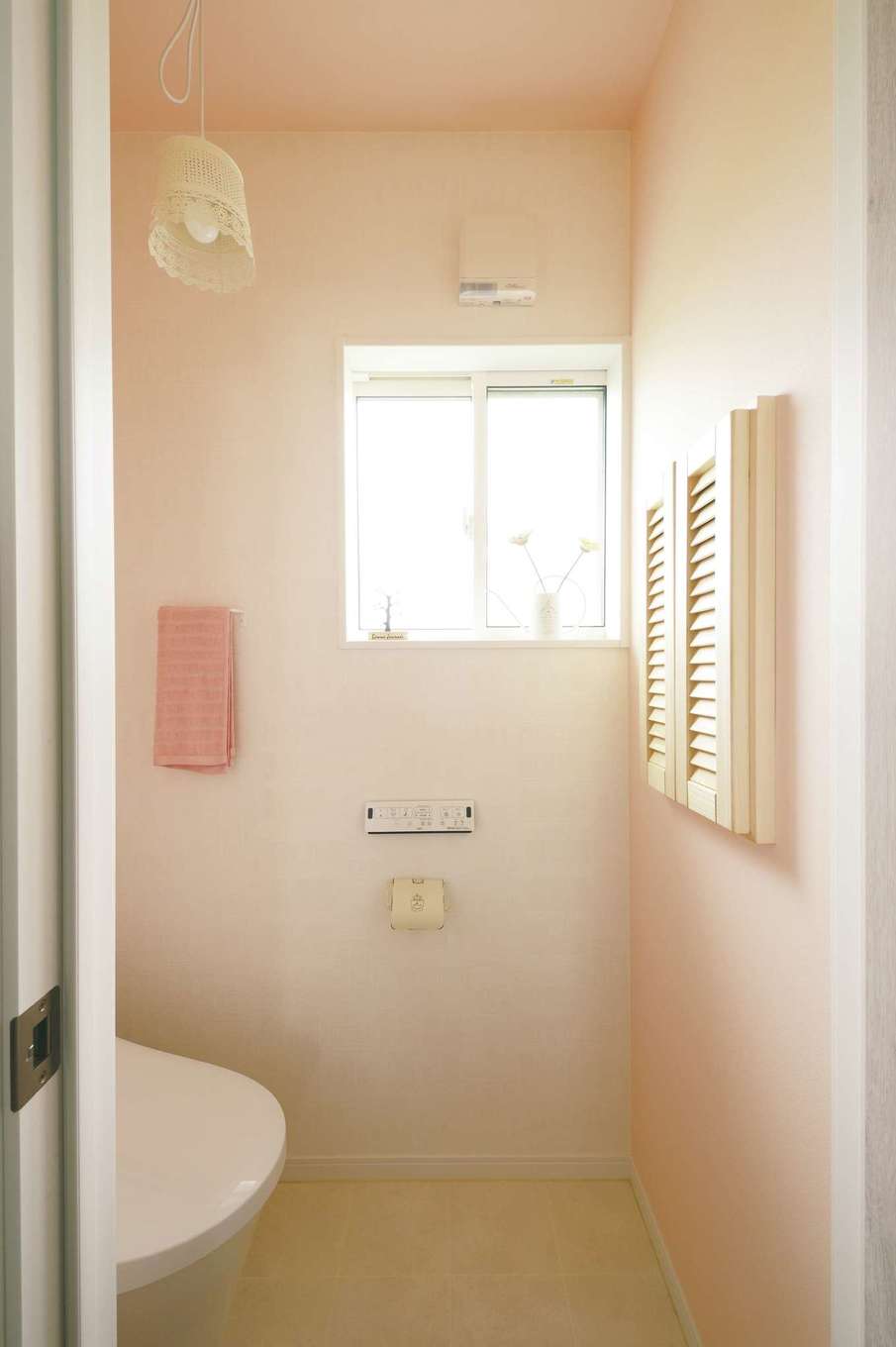 ほっと住まいる【子育て、自然素材、間取り】ピンクを基調にしたフレンチテイストのトイレには、ネットで見つけたお気に入りの照明を設置