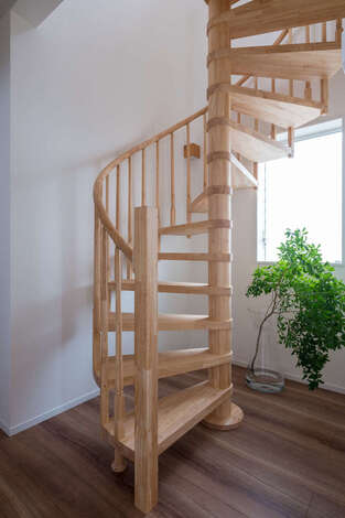 『ALAIN」が得意とする木のらせん階段。美しい曲線が暮らしを優雅に彩ってくれる。窓の外の景色を眺めながら階段を上り下りでき、気持ちがゆたかになれる