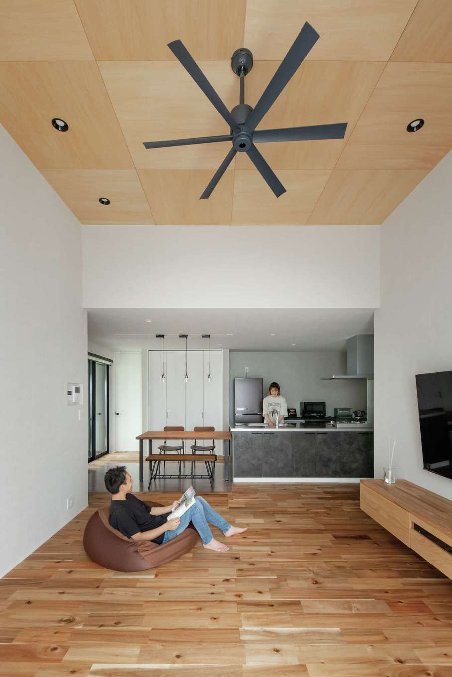 幹工務店【趣味、平屋、ガレージ】高天井のリビングではアカシアの床の質感を肌で感じながら、座り込んだり、ゴロゴロしたり。友人たちが遊びに来ると、みんなで一緒にここでまったり過ごすそう。宙に浮かせたTVボードは同社のオリジナル