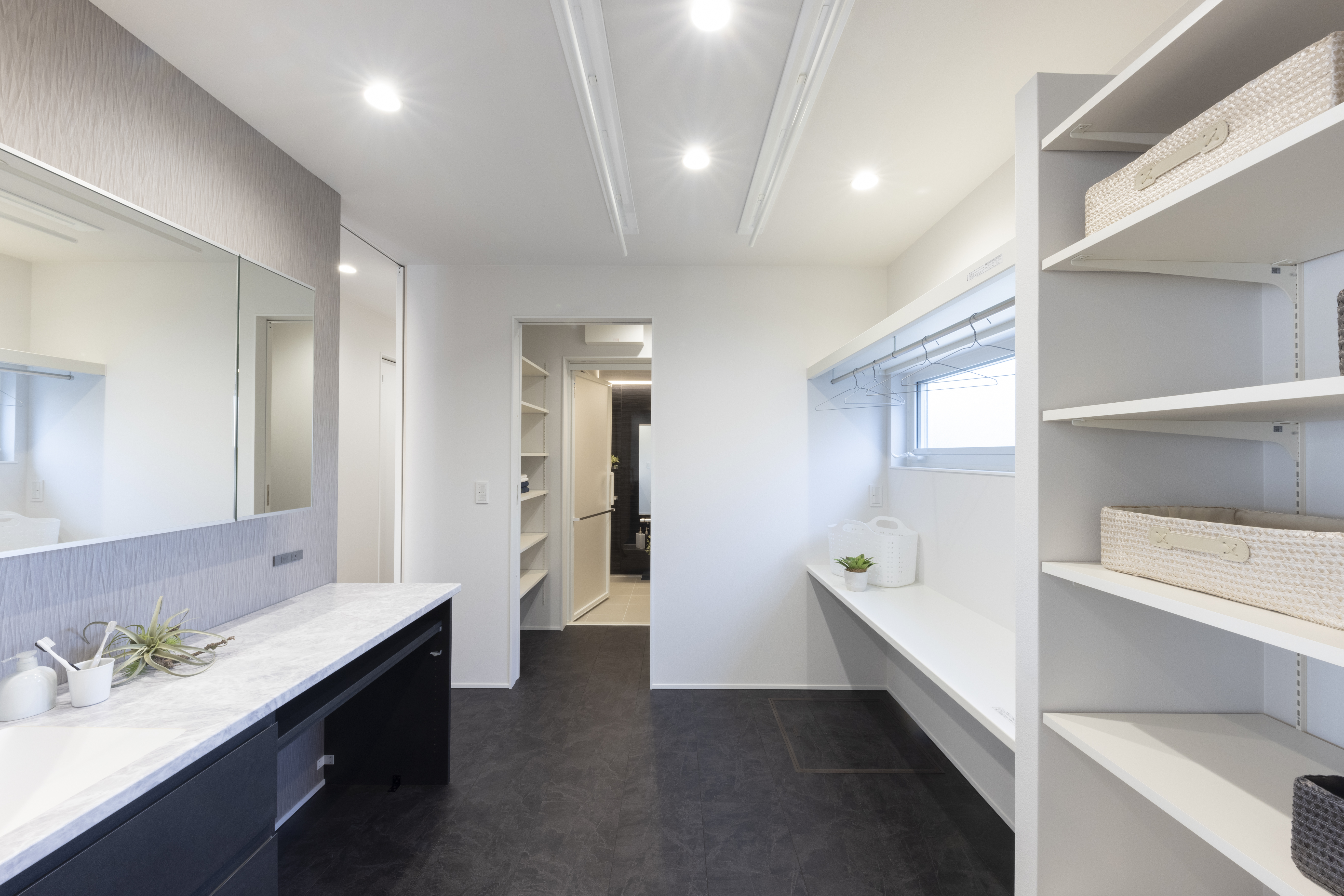 フェスティナ・レンテ｜広々とした洗面スペースは、収納棚と大きな鏡を備えており、機能的で使いやすいデザインが特徴である。白を基調とした清潔感のある空間で、毎日の準備が快適になる。