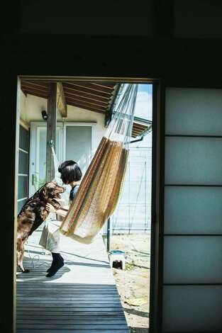 桂建設｜ウッドデッキでハンモックに揺れながら愛犬と戯れる午後のひととき