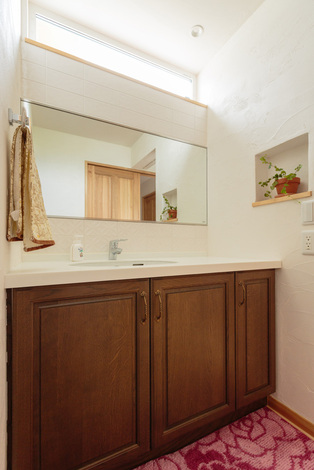 ハイサイドライトで採光たっぷりの洗面室は、気持ちよい朝を迎えられそう。色の統一感があり、清潔感のあるカラースキームも魅力。上品な花柄の白いタイルは奥さまが見学会でひと目惚れしたアイテムで、使うのがもったいないほど気に入っている