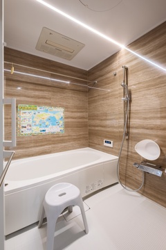 木目調の壁がリラックスを誘うバスルーム。快適さを追求した設備が整い、毎日の疲れを癒やす空間になっている。