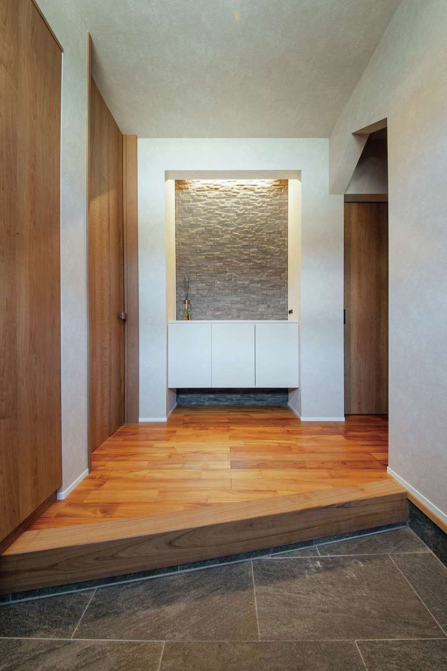 SEVEN HOUSE/セブンハウス【デザイン住宅、子育て、間取り】框を斜めにカットして広く見せた玄関ホール。正面のニッチには五月人形や季節の小物を飾る