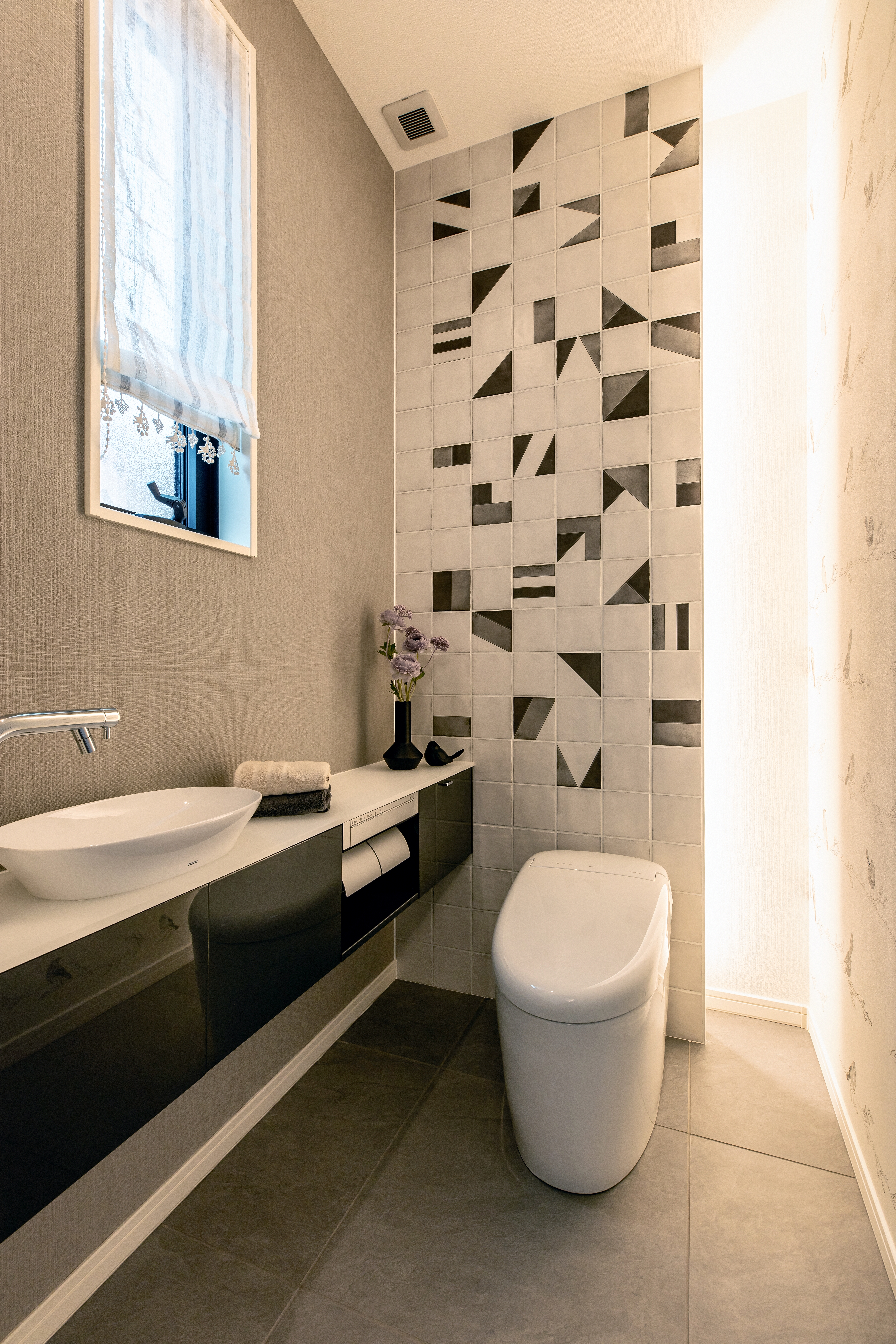 コンチネンタルホーム｜モダンなデザインのトイレ。壁の幾何学模様がスタイリッシュで、洗練された雰囲気を演出している。清潔感のある空間でリラックスできる。
