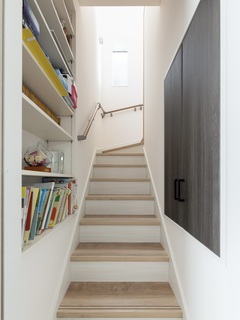 老後のことを考えて、段差を通常より低めに設定した。両サイドのは本棚と階段下のスペースを活用した収納がある。