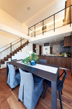 開放感のあるリビングダイニング。モダンな家具と広いスペースが特徴で、家族や友人とのくつろぎの場に最適です。上部のガラス手すりもスタイリッシュ。