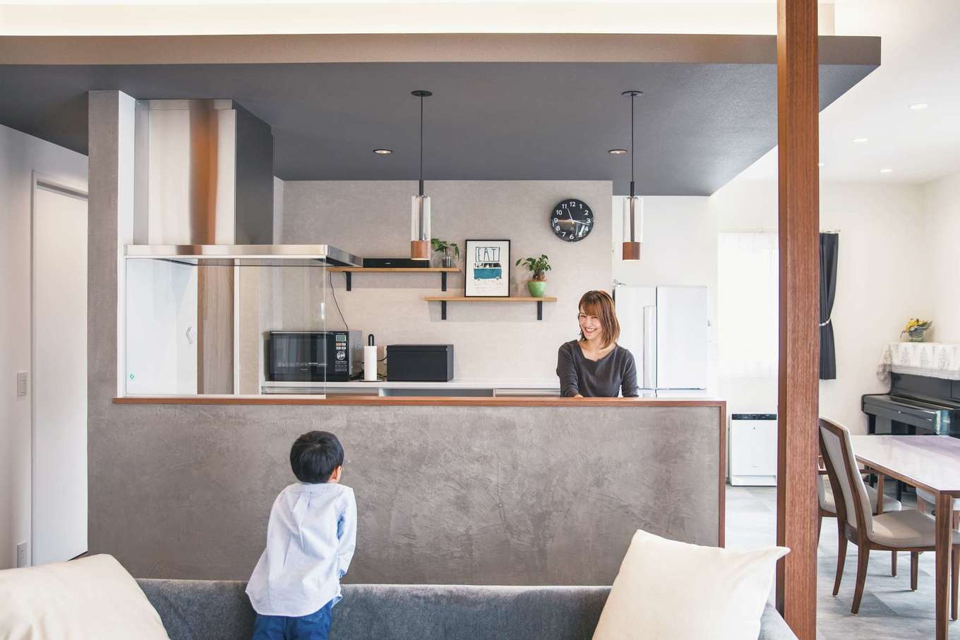 コットンハウス【デザイン住宅、子育て、省エネ】回遊式の動線が便利なアイランドキッチン。サイドの壁の通路側にはマガジンラックとマグネットウォールを設けてある