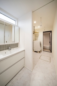 洗面室とランドリーが一体化した機能的なサニタリースペース。シンプルなデザインで清潔感があり、使いやすさを重視している。