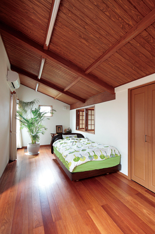 吹き抜けに面した勾配天井の2F小屋裏部屋はコテージのように安らげる