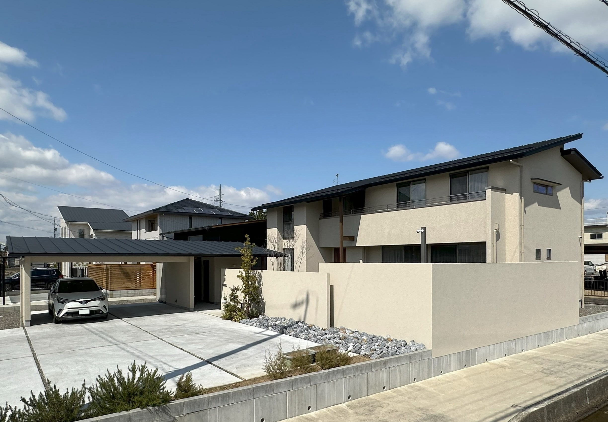 安田住宅｜安田建築設計室｜モダンなデザインの二階建て住宅の外観。広々としたカーポートを備え、快適な駐車スペースを提供する。