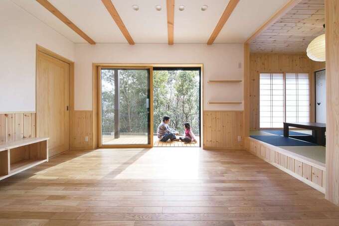 縁側のような長いウッドデッキで外と内がつながり、自然を身近に感じながら過ごせるリビング。無垢の床の経年変化も楽しみ