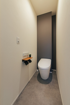 グレーのアクセントクロスでモダンで落ち着いた雰囲気のトイレ
また、壁を一部折込みデザインの利いた壁に…実は、裏側にトイレットペーパーなど小物を置けるスペースが