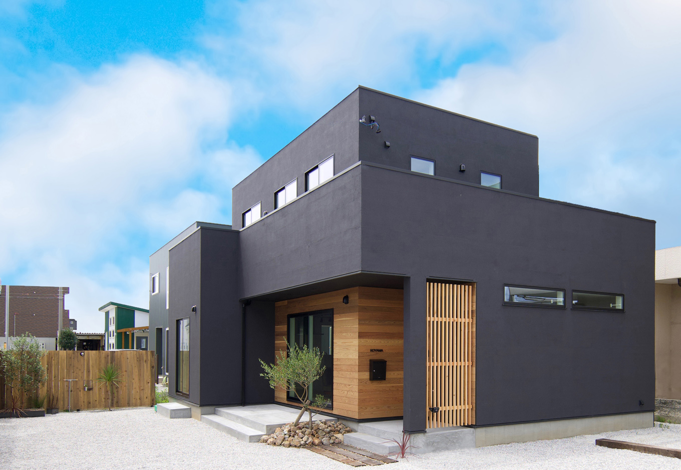 ARRCH アーチ【デザイン住宅、建築家、インテリア】ご主人が形状、素材、色のすべてにこだわった外観。黒い塗り壁で全体を引き締めつつ、フォルムはシンプルにデザイン。玄関を奥まらせて格調高い雰囲気をプラスした