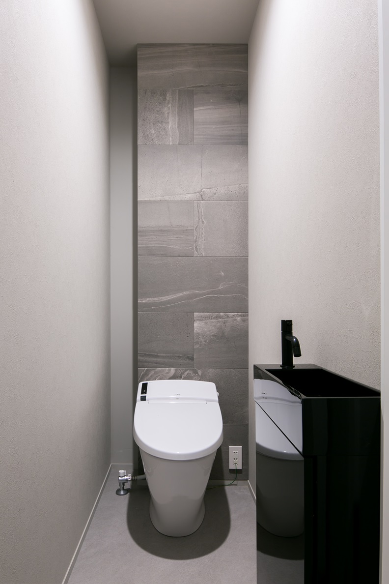 シンプル｜エコカラットを採用しかっこいい雰囲気なトイレ。
背面には棚を設置し、掃除用具等を隠して収納することができる