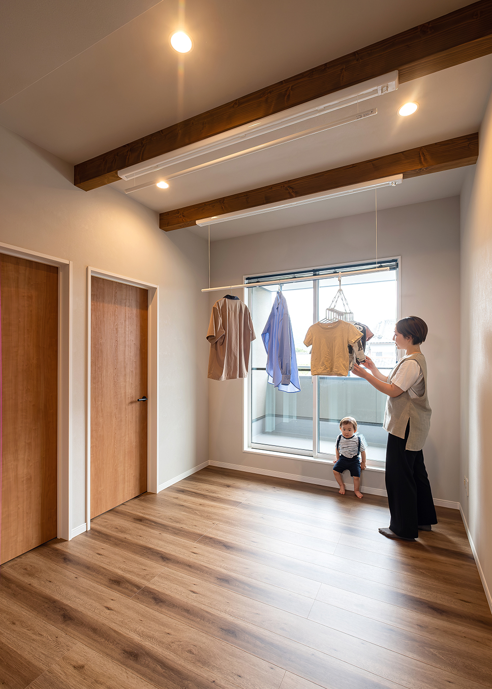 WOODART（ウッドアート）【子育て、収納力、省エネ】2階のフリースペースには、昇降式のスクリーンを設置して室内干しができるように。共働き家族の日常に寄り添うアイデアだ