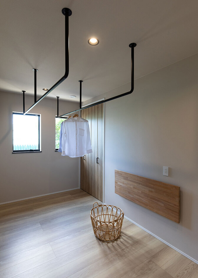 洗濯物は、2階の日当たりの良い場所に設けたランドリールームで室内干しに。第一種換気システムの効果で、毎日カラリとした仕上がりになる。たたむ作業やアイロンがけがその場で行えるよう、折りたたみ式の作業台も用意した