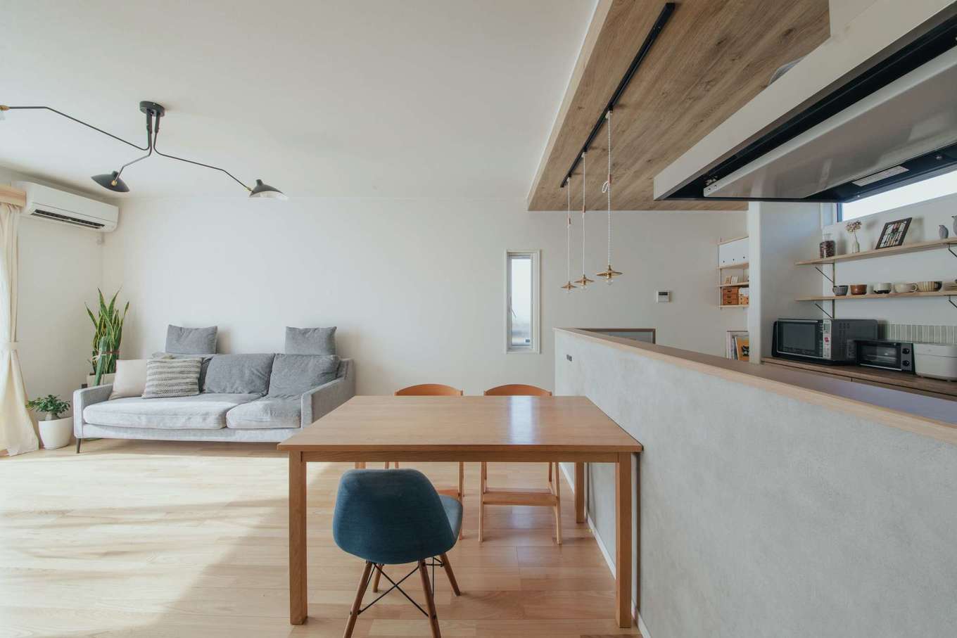 子育て安心住宅 Design Craft Office【デザイン住宅、子育て、間取り】木目の折り下げ天井と表情のあるグレーのクロスで、空間を穏やかに分割。カウンターは手元が見えない高さを希望