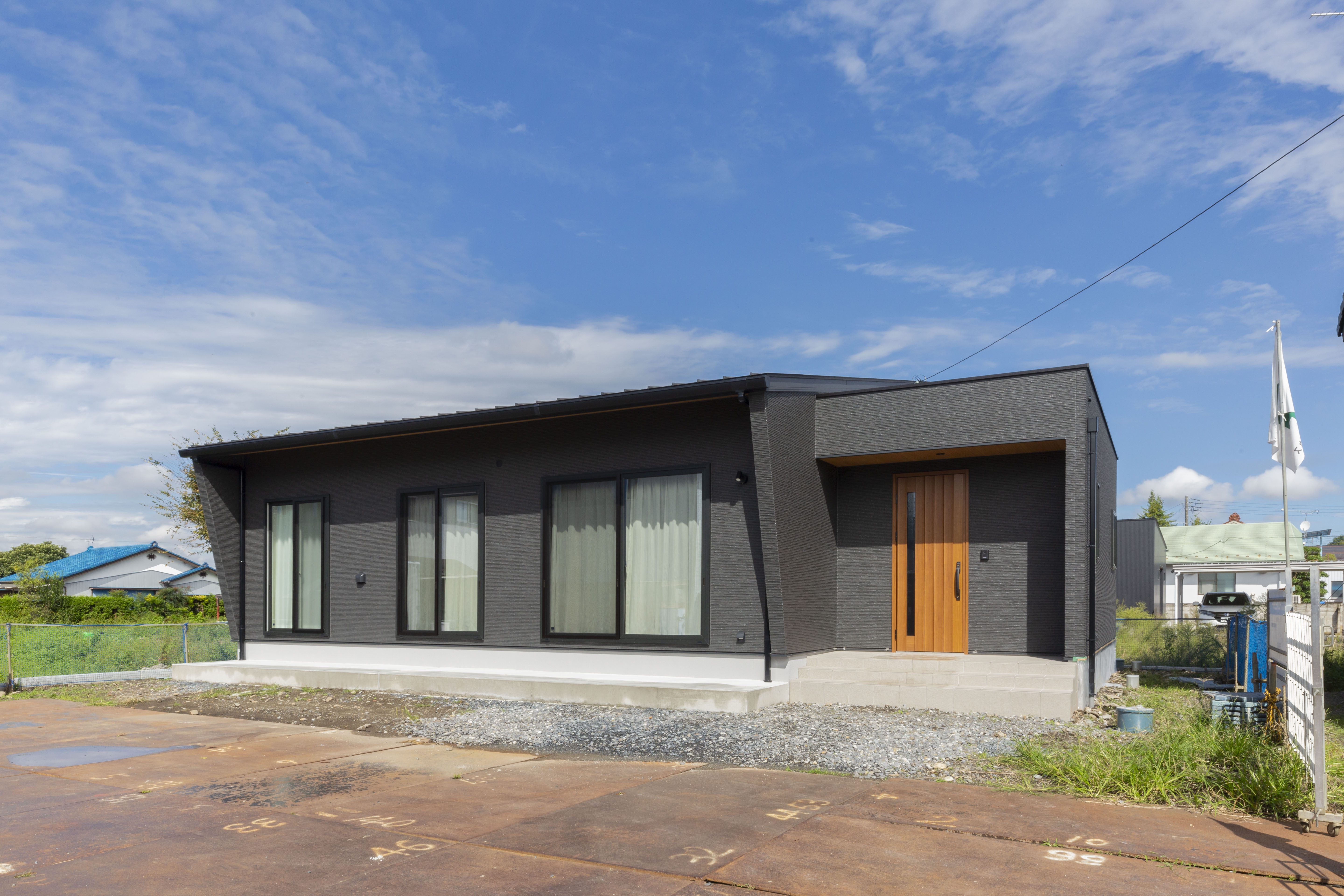 感動ハウス｜シンプルかつモダンなデザインの平屋建物外観。広々とした敷地に位置し、大きな窓が印象的で光を取り入れやすい設計である。