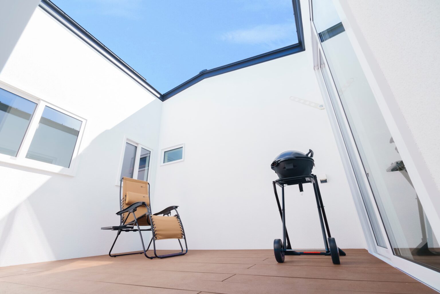 Touch House（タッチハウス）【子育て、間取り、平屋】夕暮れどきには、ベンチを出して晩酌タイムも楽しめる中庭。リビングの壁に映し出した映画を、この場所からも楽しめるのだそう。夏にはBBQやプール遊びで子どもたちの楽しそうな笑い声が響く