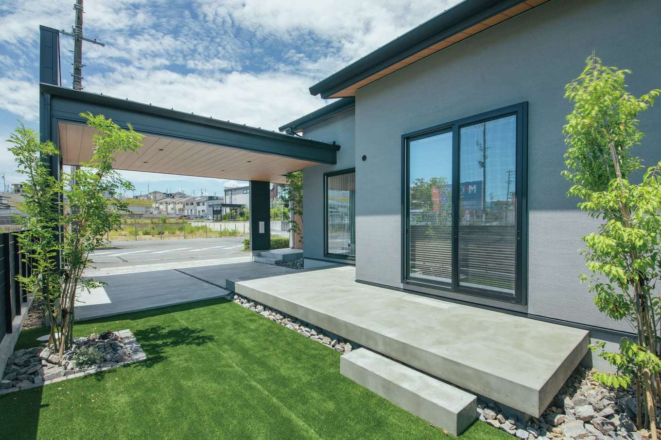 Yamaguchi Design 【磐田市見付1853‐20・モデルハウス】ガレージの奥の庭にはテラスを配置し、人工芝を敷いて、アウトドアを楽しめる空間に！
