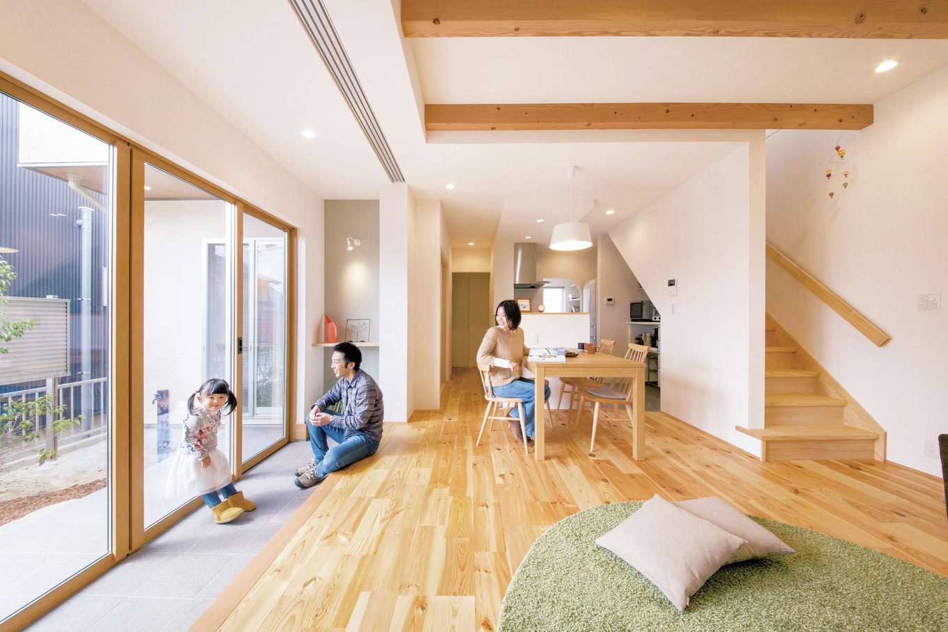 SEVEN HOUSE/セブンハウス【デザイン住宅、子育て、自然素材】土間のあるLDK。無垢の床と白の空間に天井の梁がアクセント。土間を挟んだ庭の借景は、一幅の絵画のよう