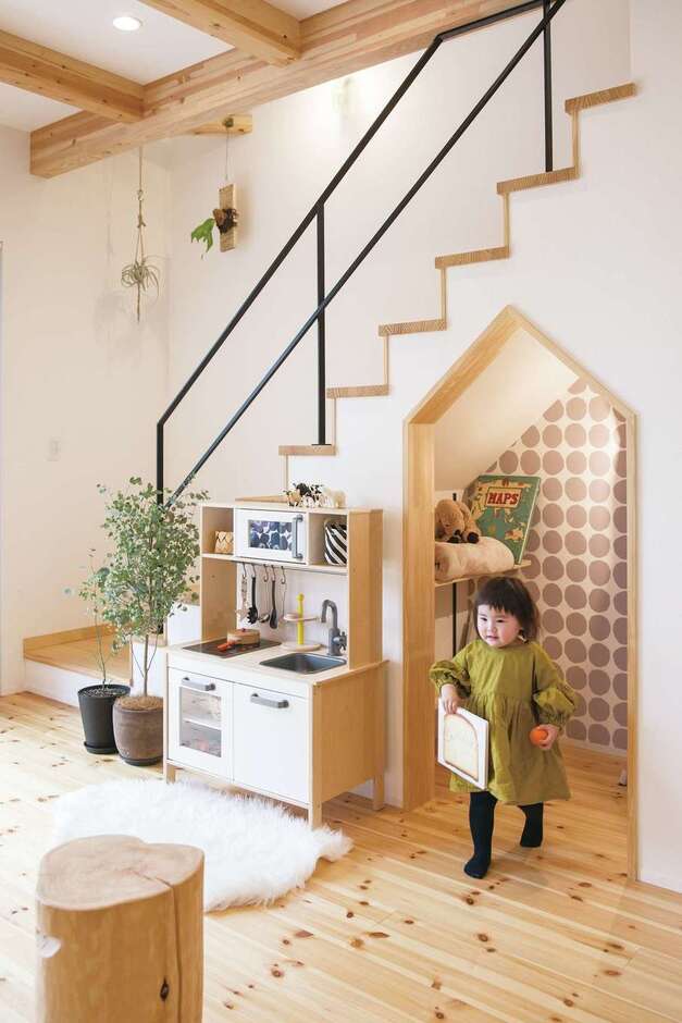「階段下を収納にしてみては？」と担当の西岡さんから提案され、完成したのがこちら。「せっかくならかわいくしようと思い、入り口を家の形にして壁紙にもこだわったら、一番のお気に入りのスペースになりました」と奥さま。子ども達も率先して片付けに参加している