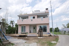 二階建てのモダンな外観。広々としたバルコニーが特徴で、周囲の自然と調和したデザインが魅力的な住宅。