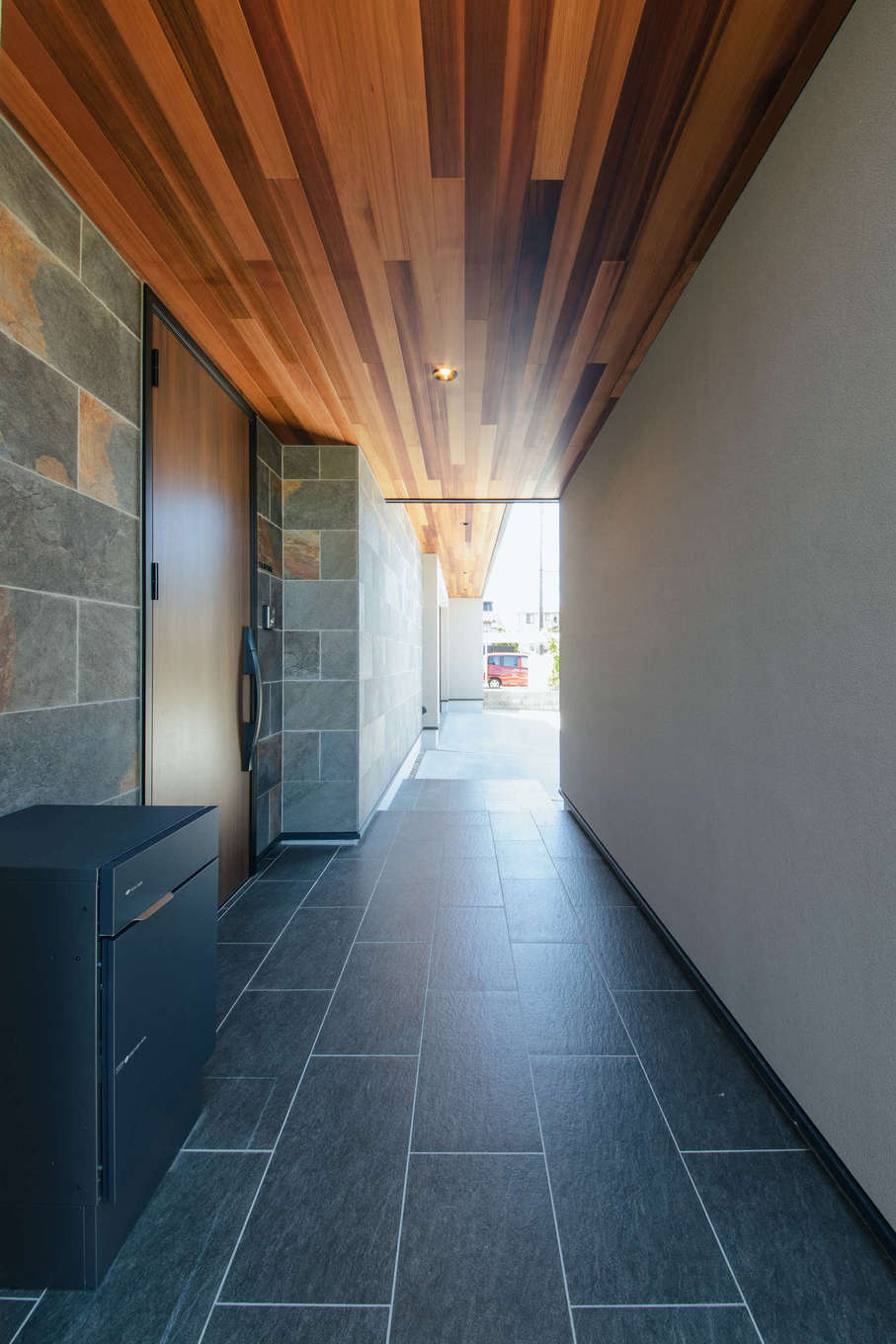 チェックハウスプラス浜松【建築家、平屋、ガレージ】石のタイルと軒天井が美しい玄関ポーチ