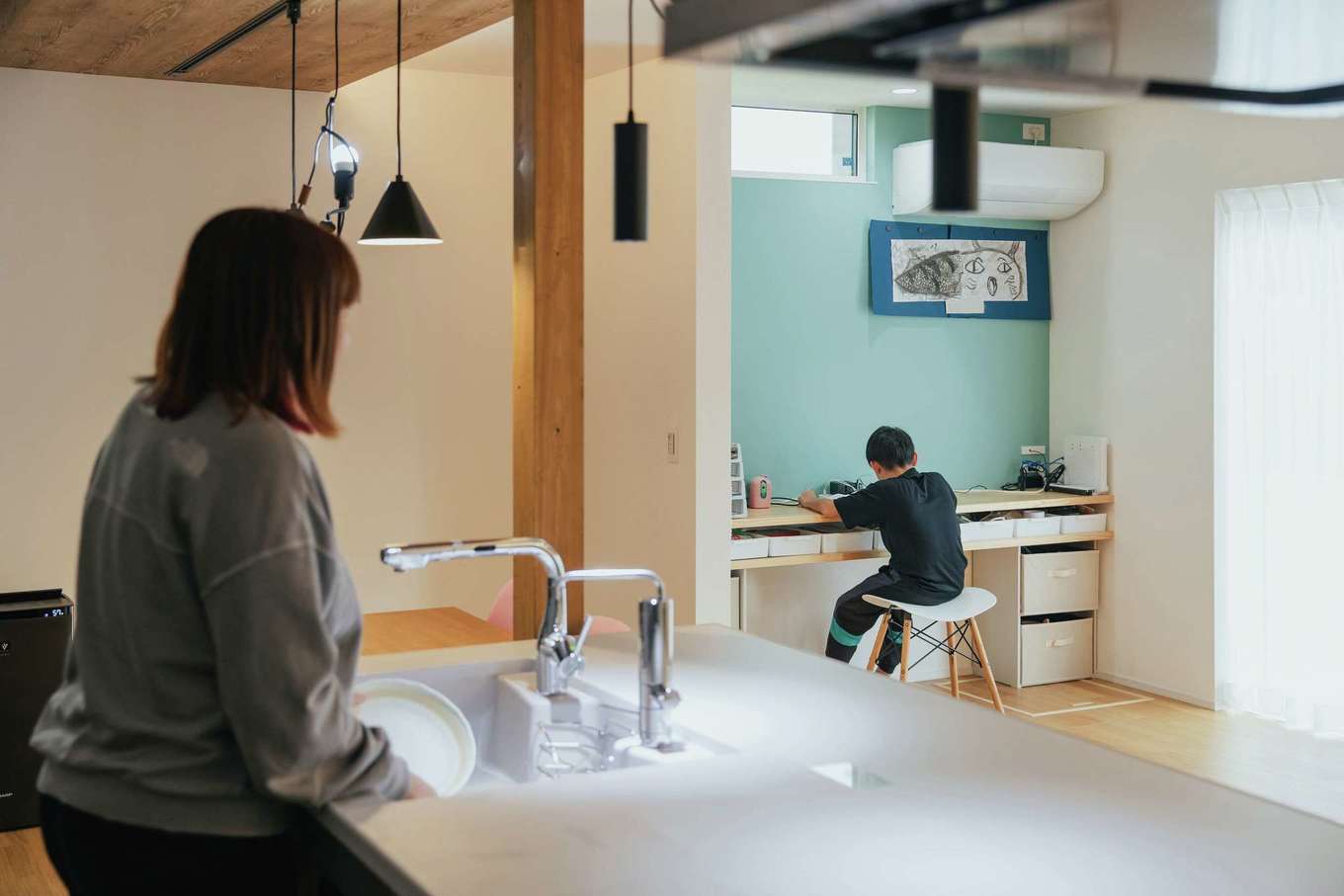子育て安心住宅 Design Craft Office【デザイン住宅、収納力、間取り】リビングのエコカラットの壁に沿ってスタディカウンターを用意。キッチンから子どもが勉強している様子を見守れる
