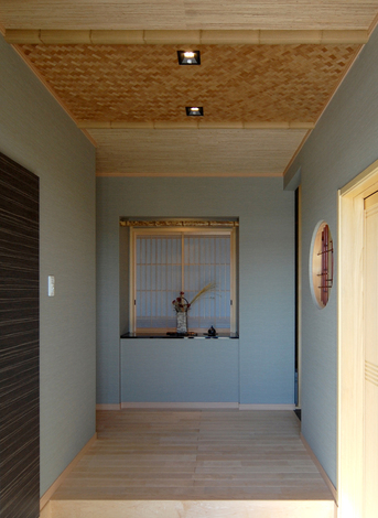 正面には大きなニッチがあり、その奥は収納棚に。この他、土間の左側にも大容量の収納を設置。土間右側の格子戸を開けると、直接リビングに通じている