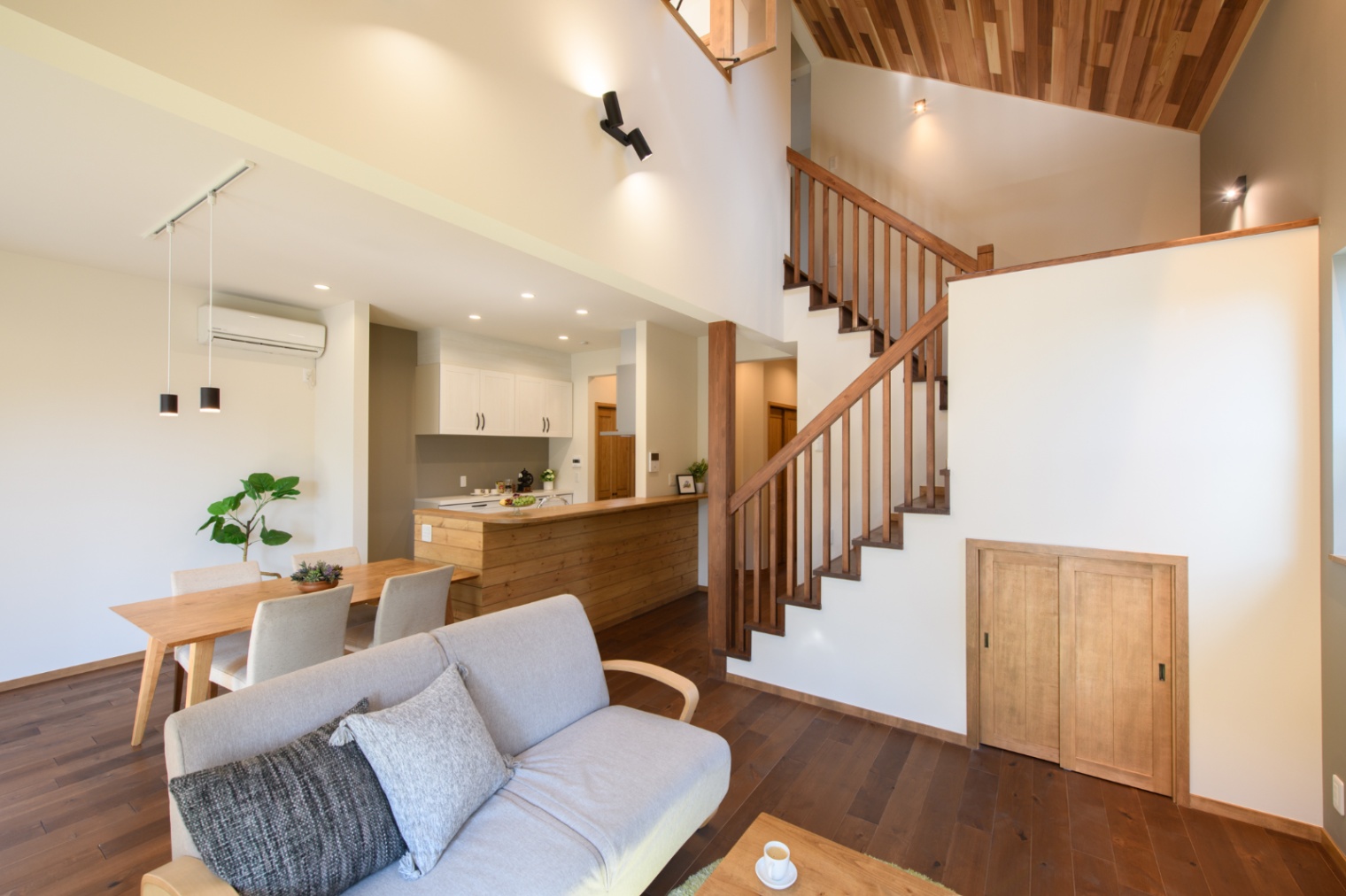 Sus∞Eco Home（サスエコホーム）｜開放感あふれるLDK。木目と白を基調としたインテリアで、階段がアクセントとなり、空間全体に温かみを与えている。