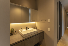 洗面台は脱衣室とは別にし、オープンスペースにレイアウト。三面鏡の中に細かなものを収納して、生活感が出ないようにしている