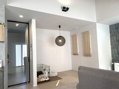 モダンなデザインの畳スペース。シックな照明が空間を引き締め、ペット用スペースも併設されている。心地よさと実用性を兼ね備えた空間である。