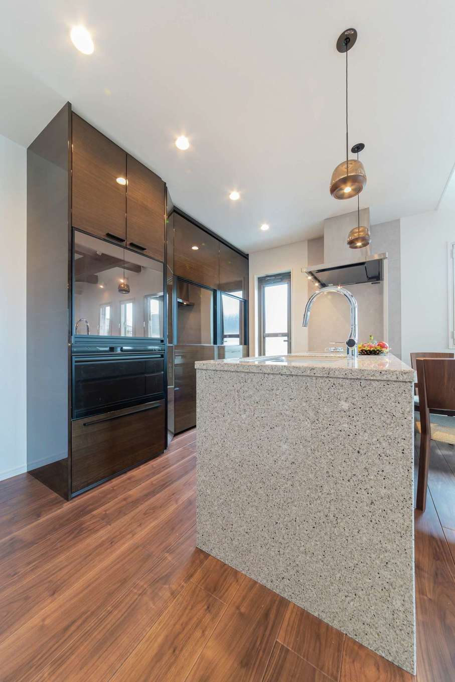 大成工務店【デザイン住宅、収納力、高級住宅】快適に暮らすために、水回りなどの設備にもこだわった。キッチンは人工大理石のワークトップに。背面の収納は鏡面仕上げでスタイリッシュな印象