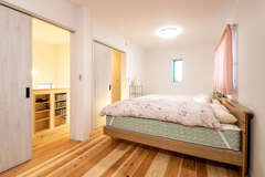 2階の子ども部屋は現在、家族5人の寝室として利用。お子さんが大きくなったら子ども部屋として広々と使い、必要に応じて部屋を仕切れるように入り口を2つ設けてある。スギの無垢の床は柔らかで温かく、お子さんが座り込んで遊んでいても心地よい