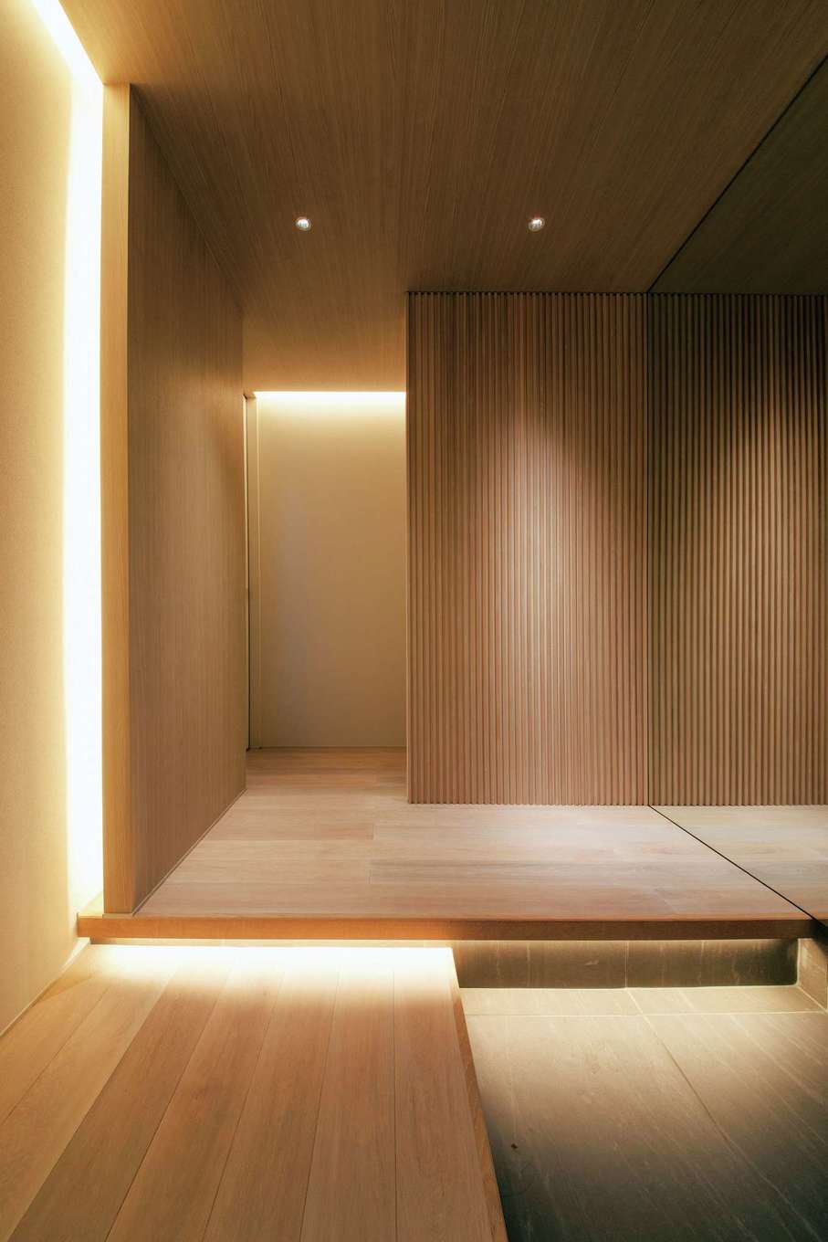 トーリンホーム【デザイン住宅、省エネ、建築家】特大の全身鏡を採用し、より広く見せる玄関ホール。木と間接照明を上手に使った空間は、上質でありながら暮らしに寄り添う温もりを感じさせる