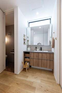 好みの洗面ボウルや面材を組み合わせたカスタムメイドの洗面台。ヘリンボーンの床にペンダントライトの灯りが広がるトイレもおしゃれ