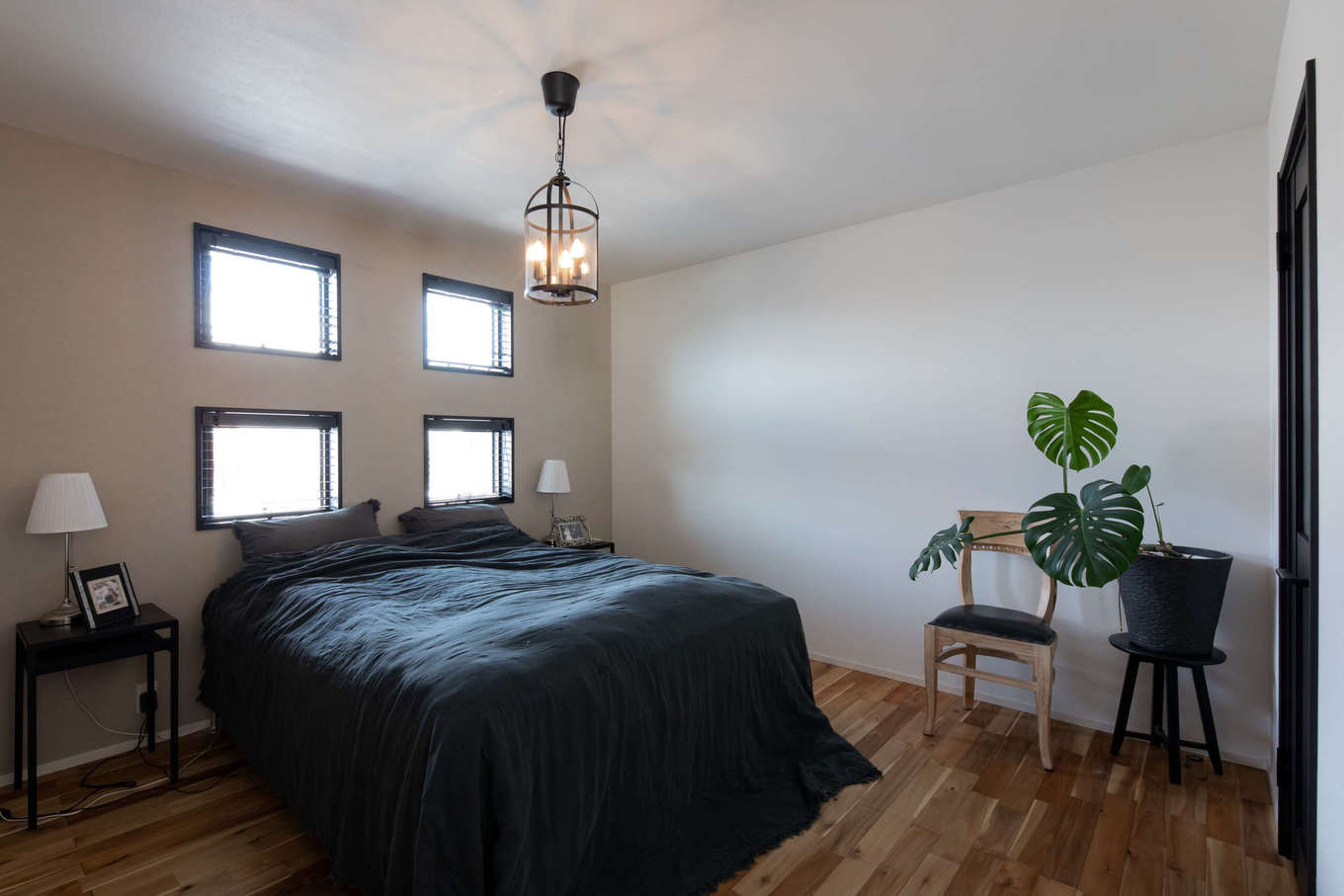 幸和ハウジング【デザイン住宅、夫婦で暮らす、ガレージ】主寝室はペンダント照明やスタンド照明を効果的に用い、ホテルライクに演出。四つ窓はダイニングとお揃いのデザイン