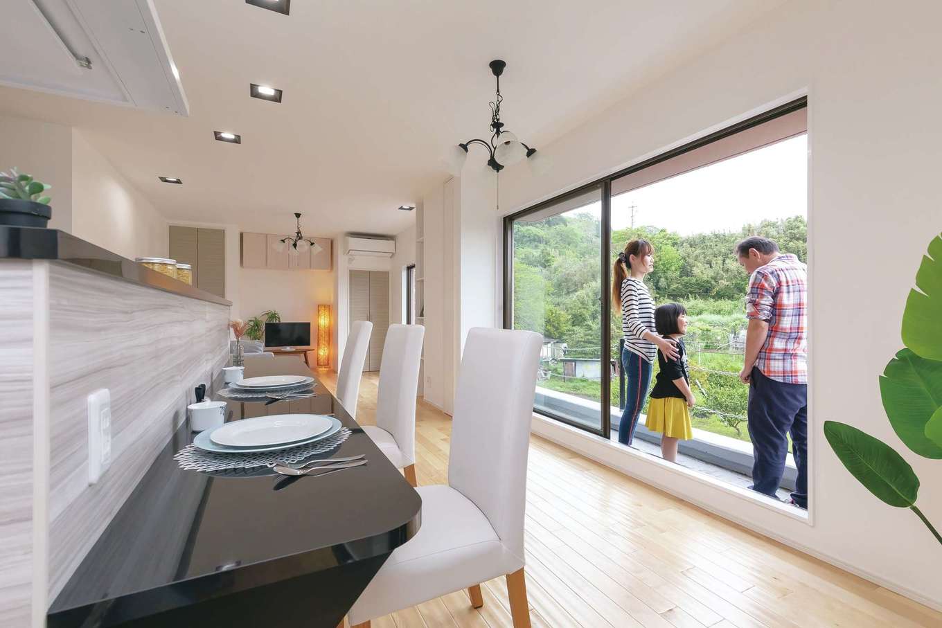 nattoku住宅｜明るく開放的なLDKはアイランドキッチンを主役にプランニング。狭くなるのでダイニングテーブルは置かず、カウンターで食卓を囲むスタイルに。窓の外には緑豊かな山の景色が広がり、料理タイムもより楽しくなりそう。壁は調湿効果にすぐれた漆喰を標準で使用