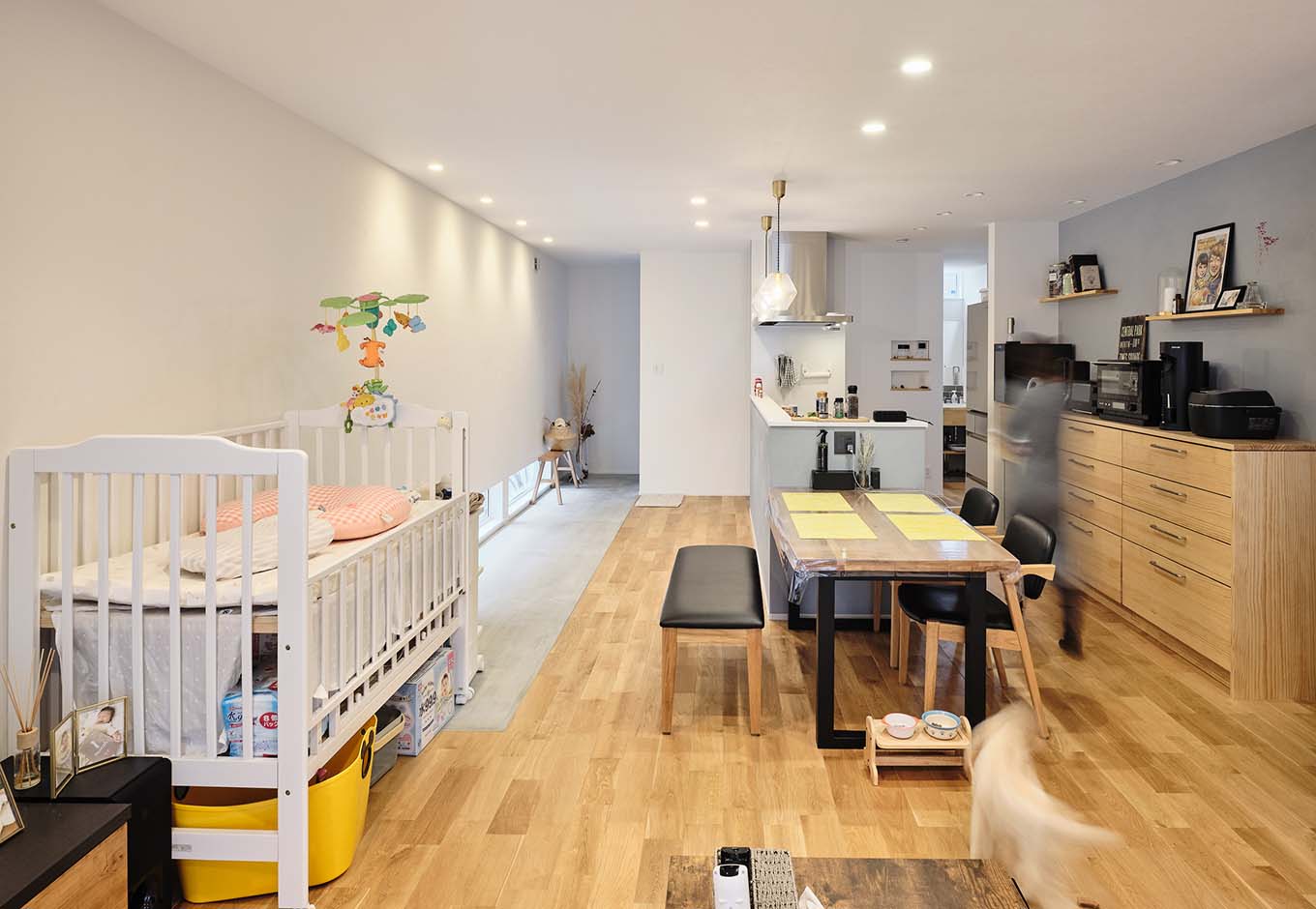 平屋建築ブルーハウス【ペット、建築家、平屋】左右からの2本の動線を使い分け、玄関からリビングへ。ダイニングテーブルはキッチンと一列に並べたことで、配膳や片付けが便利に
