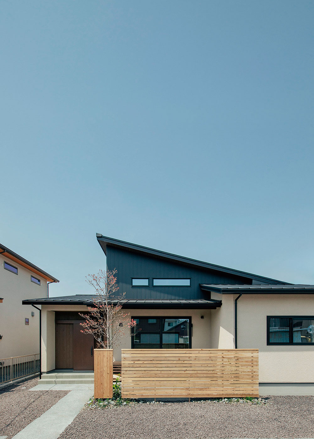フジモクの家（富士木材）【富士市五貫島6-7・モデルハウス】外壁は優れた耐久性や防火性をもつパワーボードのフラット目地仕上げ。上質な雰囲気を漂わせつつ、メンテナンスサイクルを伸ばし、維持費を削減する。上部はアクセントにガルバリウム鋼板を使用