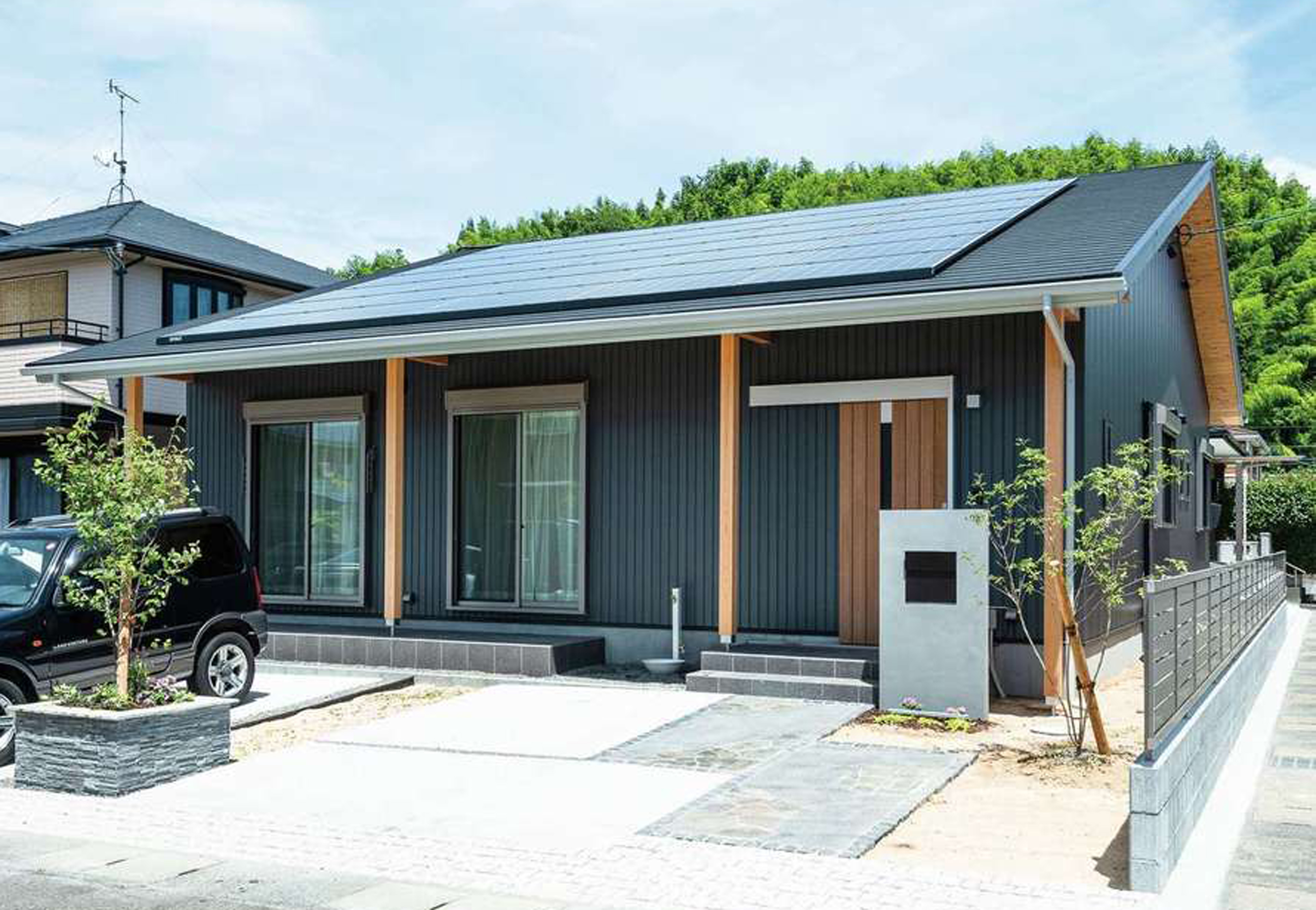 福工房【趣味、自然素材、平屋】黒いガルバリウムと柱や軒天井の杉板のコントラストでかっこよさを演出。周囲の景観にも溶け込んでいる