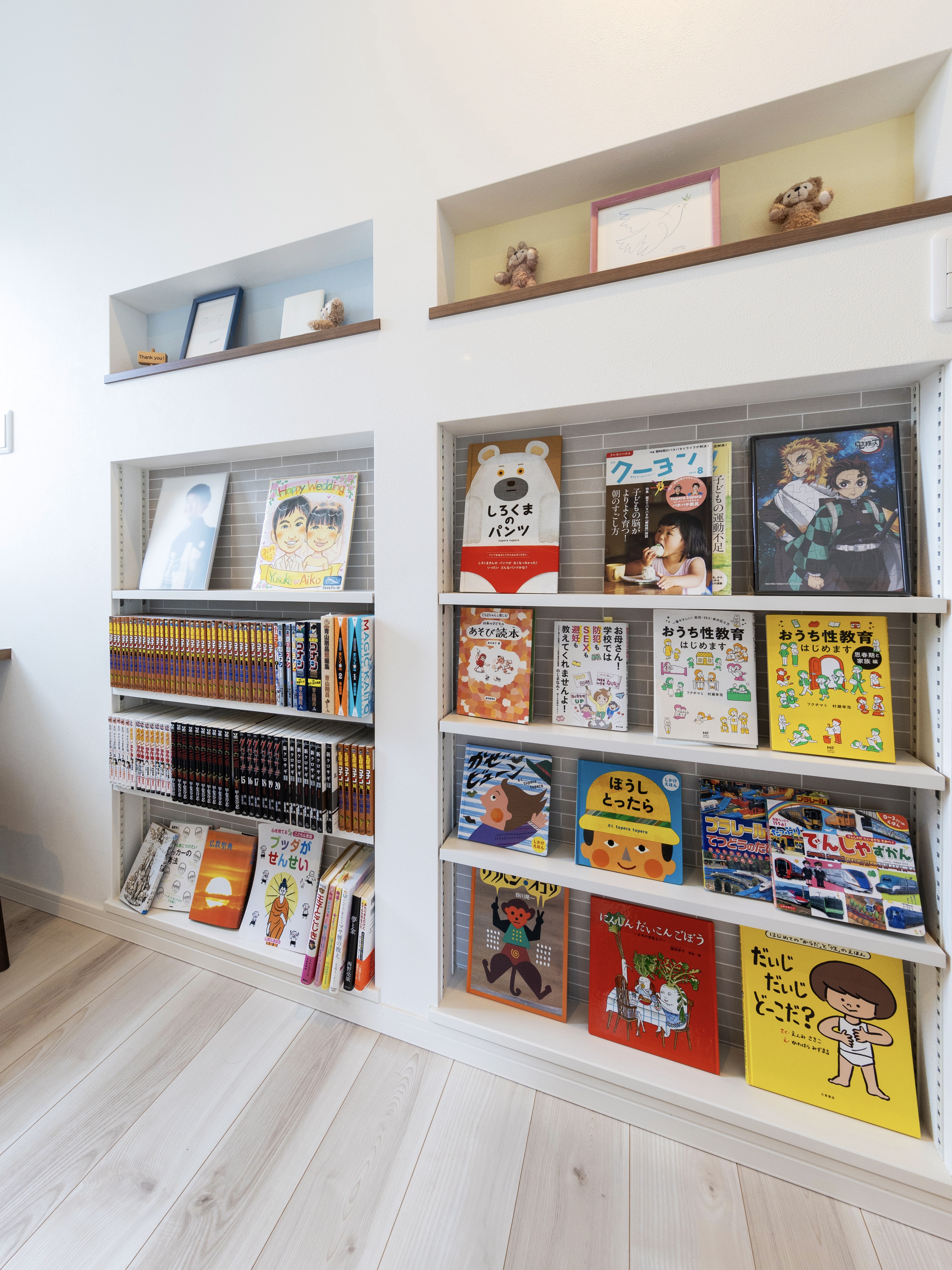 エスホーム｜壁に設置された本棚が特徴的なスペース。絵本やコミックがディスプレイされており、家族みんなが手軽に読書を楽しめる空間である。棚の上には小物を飾るスペースも。