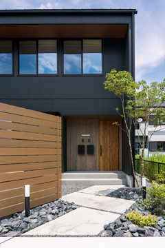 黒色と木目調の相性が抜群な玄関。軒を出し雨が降っても濡れにくい設計になっている。