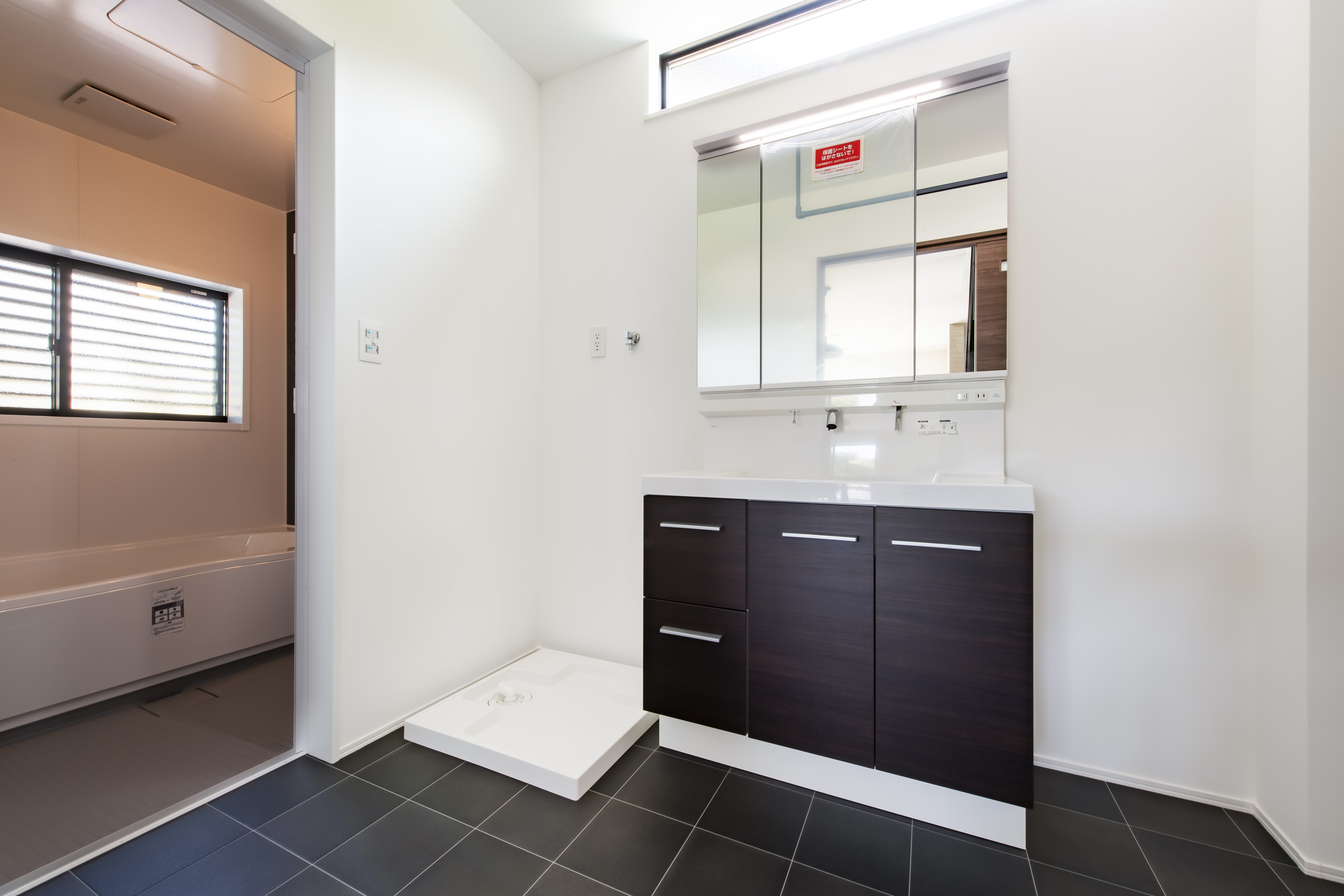 スズイチ｜モダンでスタイリッシュな洗面スペース。広々としたスペースに加え、洗面台や収納が整然と配置され、機能性に優れている。